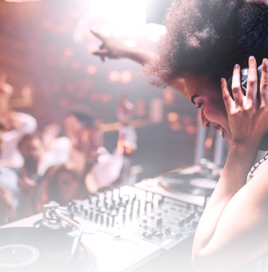 A woman is sitting at the dj booth